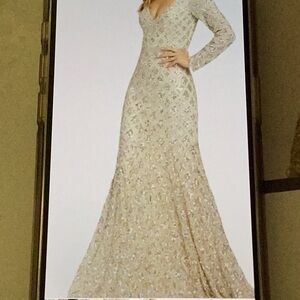 MacDougal long sequin gown with slight train silver beads on a tan background…